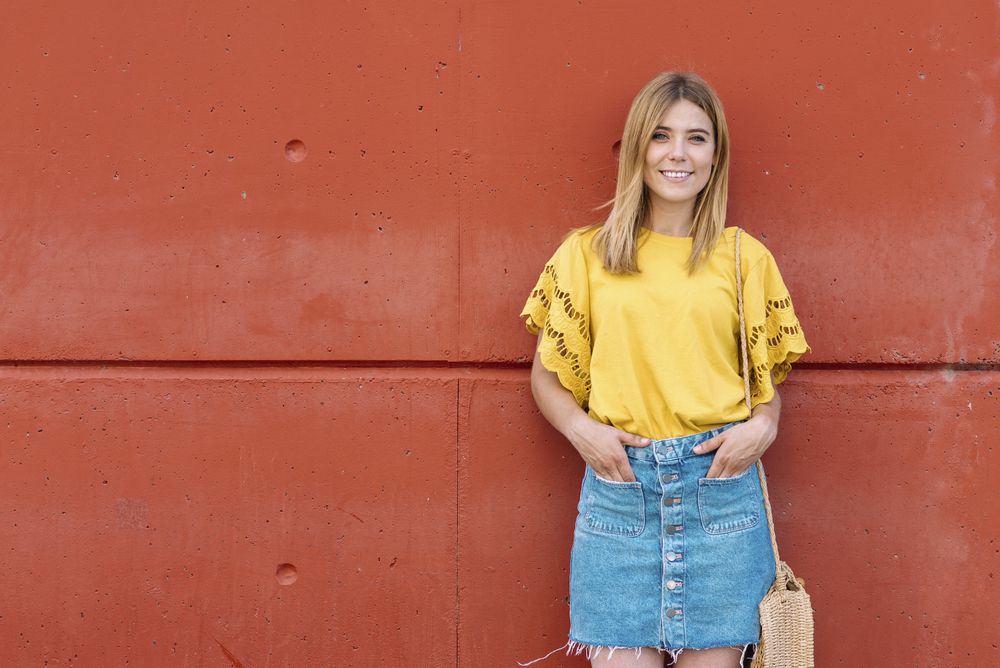 Cheerful woman standing on orange background