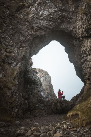 Woman sitting inside rocky cave