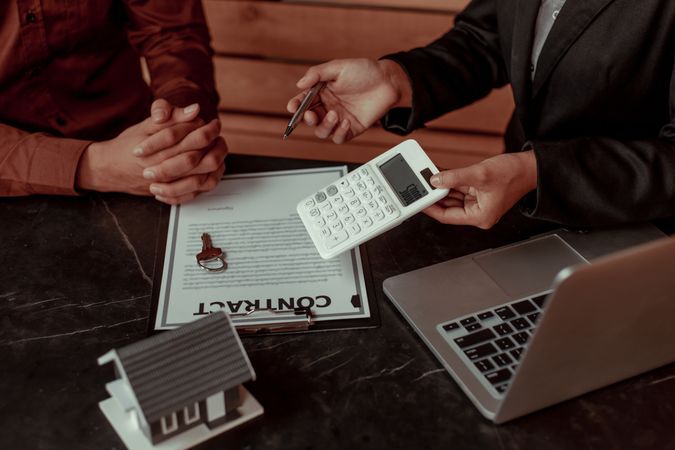 Real Estate Agent Discussing Contract Details With Client in a Modern Office