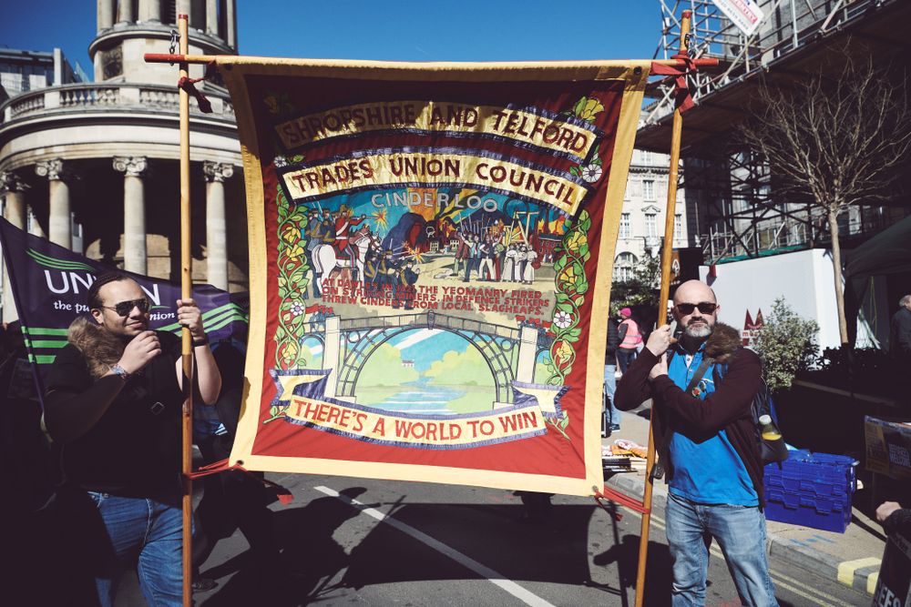 London, England, United Kingdom - March 19 2022: Two me holding colorful banner at march