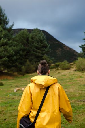 Person in yellow raincoat walking in forest