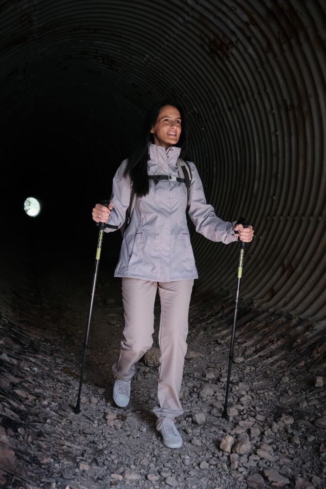 Positive Hispanic woman walking in tunnel
