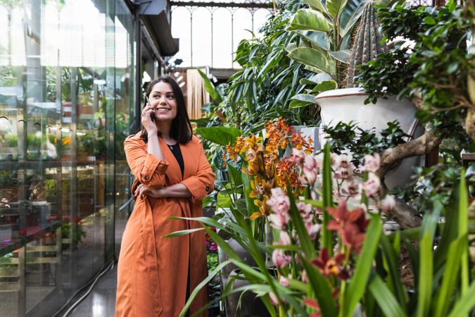 Content woman using the cellphone in garden center