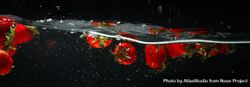 Side view banner of wave of water on dark background with floating strawberries bEj9o0