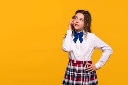 Girl talking on red phone, thoughtful expression
