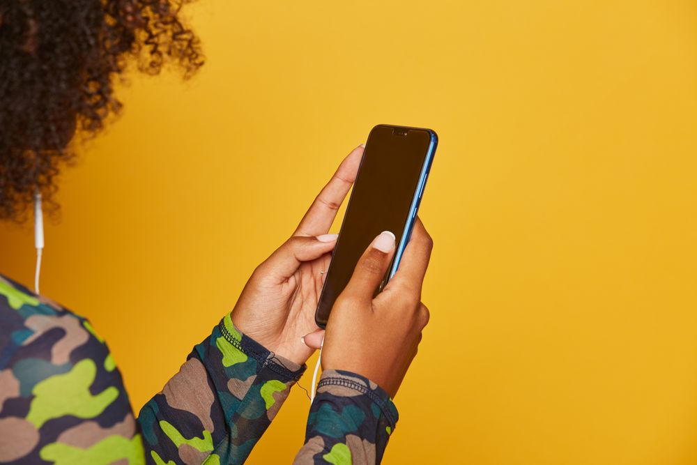 Close-up of anonymous young woman with smartphone