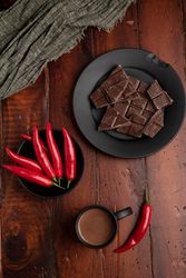 Hot beverage near plate with chocolate and pepper