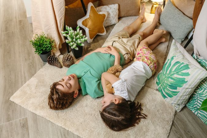 Two children sleeping lying over rug in cozy tent at home with warm and playful atmosphere