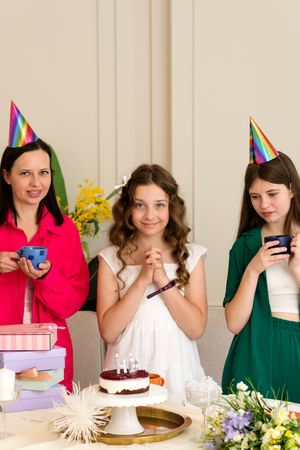 Birthday girl in white dress, surrounded by family