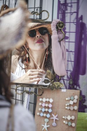 Female trying on hat looking at mirror