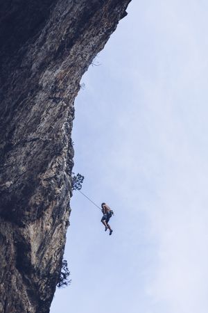 Anonymous climber handing on cliff