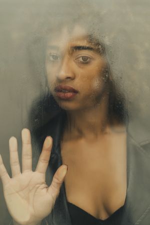 Black woman behind wet glass