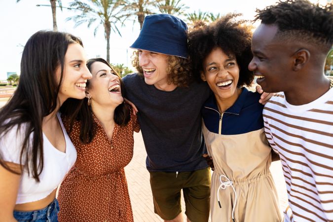 United young adult friends laughing together outside