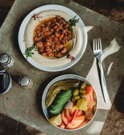 beans hummus in plate close to vegetables plate