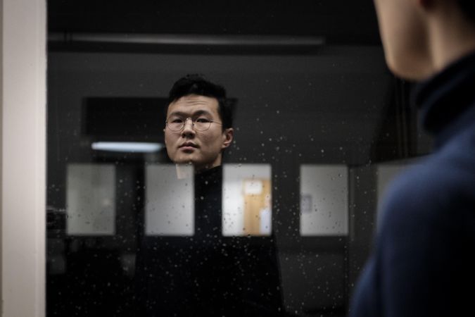 Man standing in front of glass window