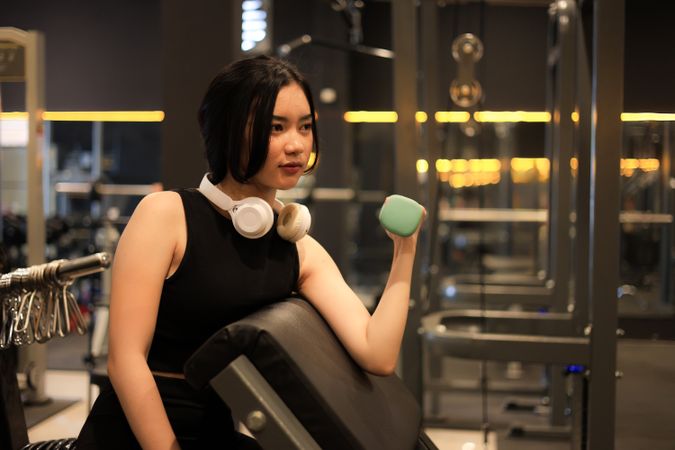 Asian Female Wearing Black Sports Bra doing Lifting Dumbbell Weight Exercise in Sport Fitness Gym.