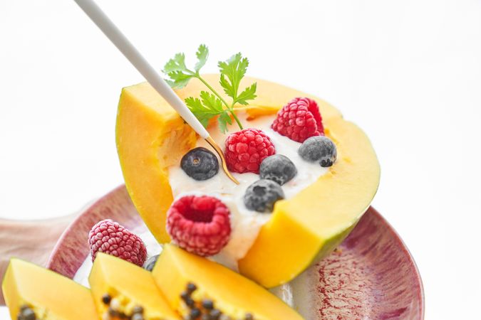Papaya with yoghurt and berries served on plate