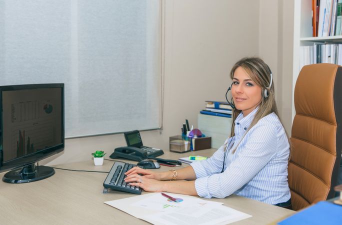 Happy woman working with charts on computer in office