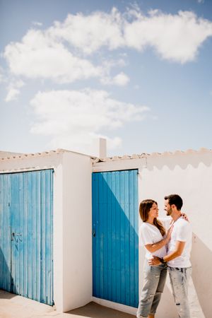 Loving couple cuddling near beach house