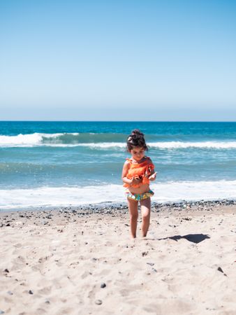 Cute twins girls playing on sandy beach
