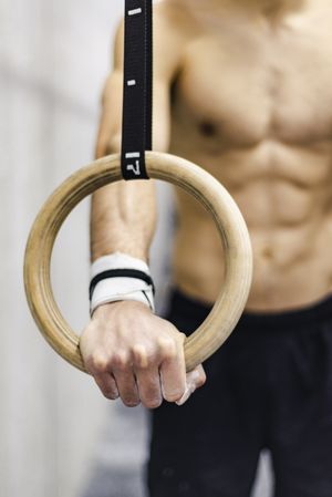 Man training with gymnastic rings in gym