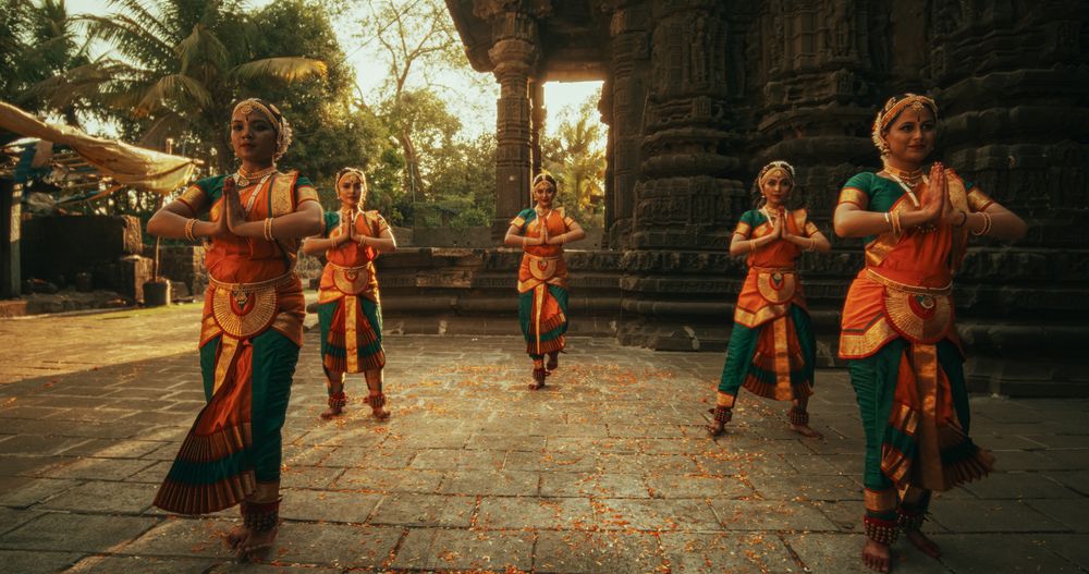 Portrait of Five Women Performing Folk Dance Choreography near Ancient Temple.