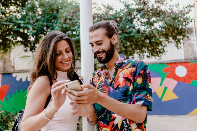 Trendy couple taking selfie on city street