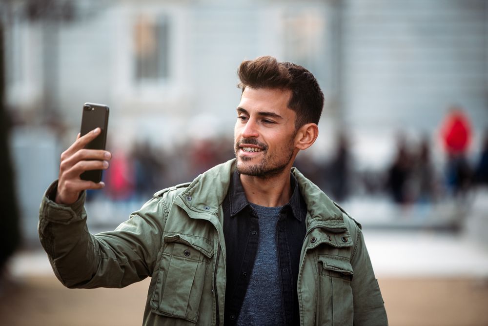 Young man on the mobile phone and walking