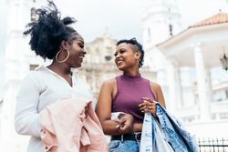 Black women talking and laughing walking in the city