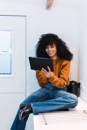 Black woman with tablet on counter