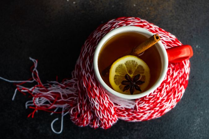 Top view of mulled tea in mug with lemon and cinnamon