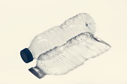 Empty small plastic bottle on white surface