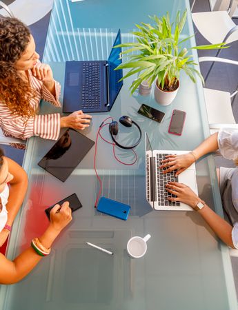 Faceless colleagues working at laptops in office