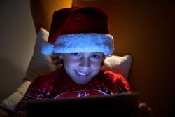 Smiling kid with tablet looking at camera