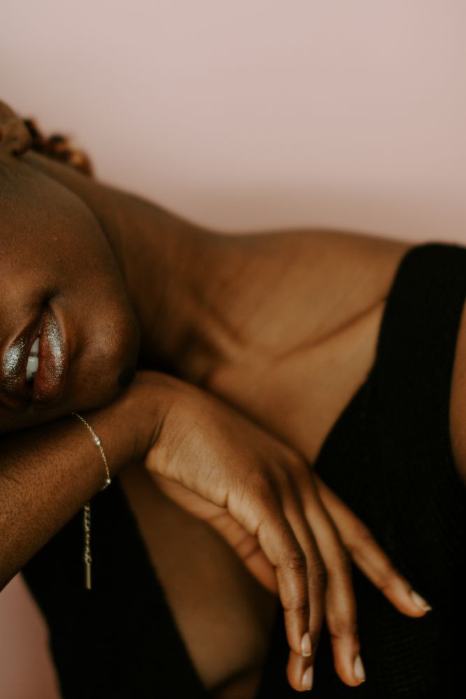Woman in dark tank top wearing gold bracelet