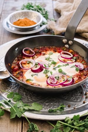 Fragrant shakshuka with onion rings in pan