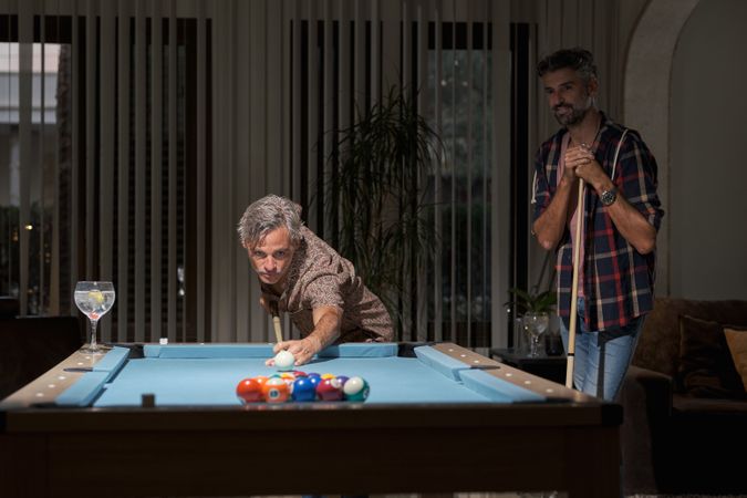 Friends playing pool and having fun together in pub