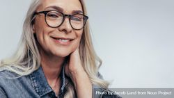 Close up of mature woman wearing glasses against grey background 4ZOKyb