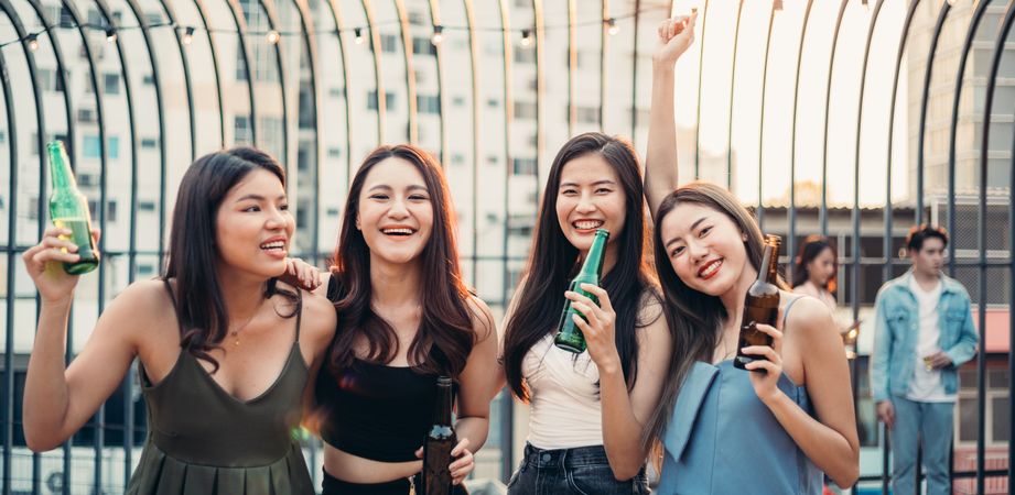 Group of Asian friends drinking beer and dancing together