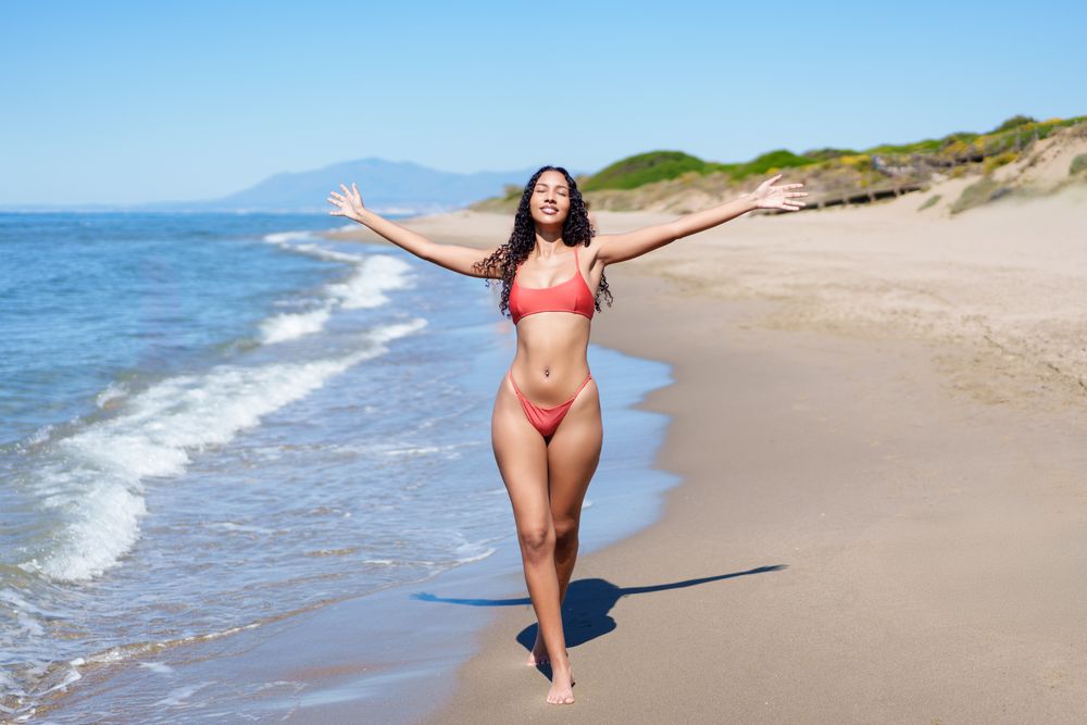 A Joyful Woman Blissfully Enjoying a Beautiful and Relaxing Day at the Sandy Beach Location