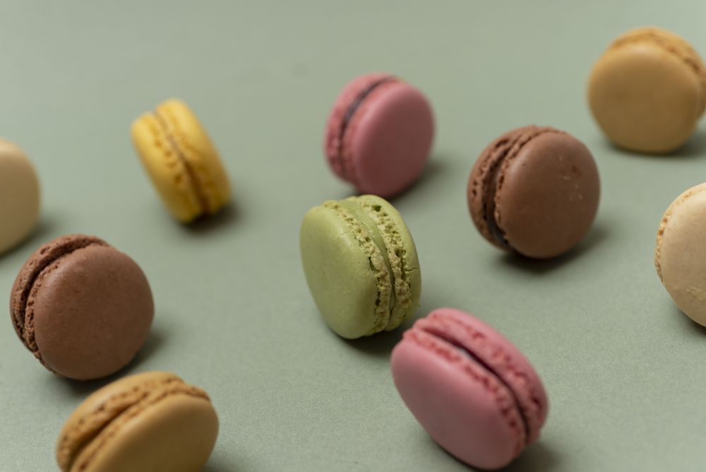 Colorful tasty  macaroons over a green background