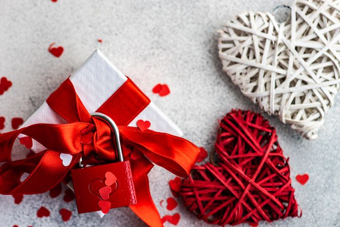 Top view of thatched heart decorations with gift box with red ribbon