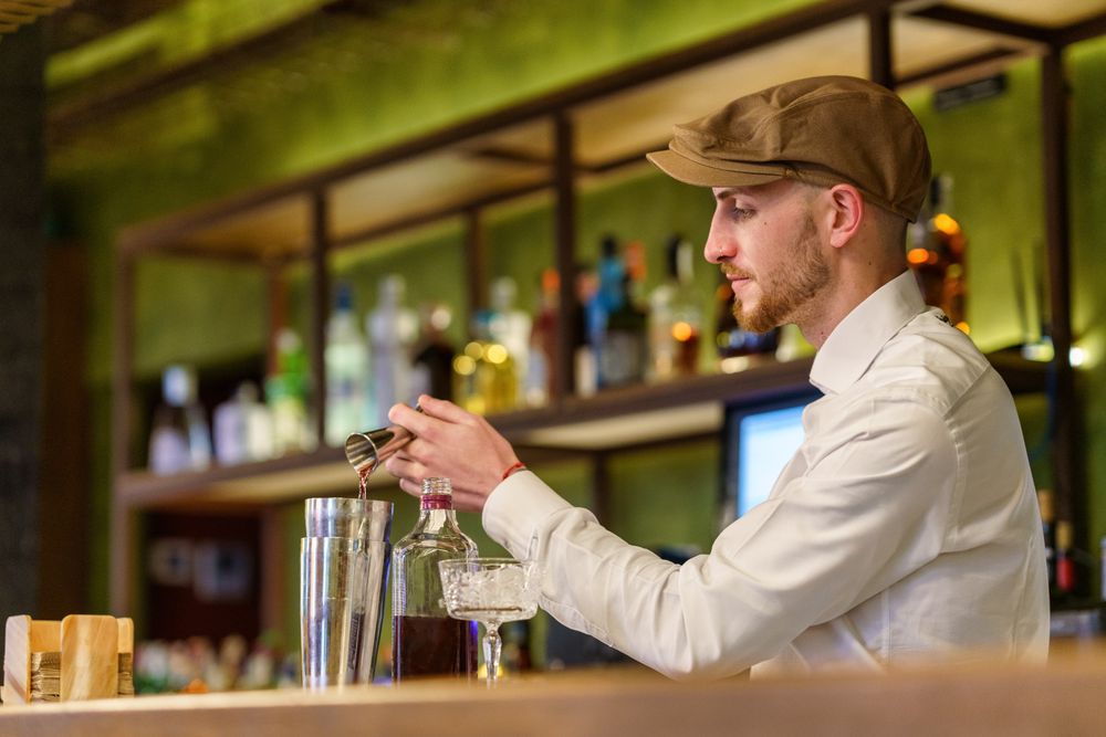 Bartender mixing ingredients in a shaker for cocktail
