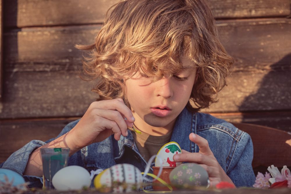Concentrated boy with Easter eggs
