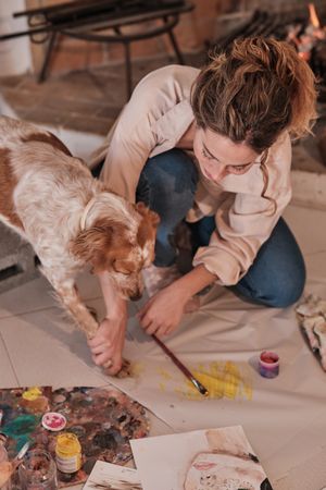 Young woman drawing with dog