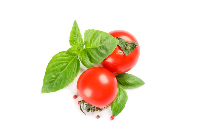 Fresh cherry tomatoes with basil and spices isolated on blank background, top view. Ripe vegetables