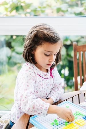 Girl playing with mosaic board game