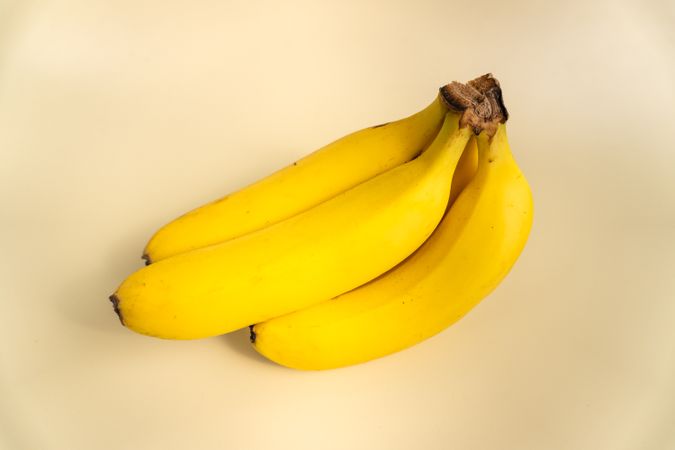 the bananas are sitting on a plain surface