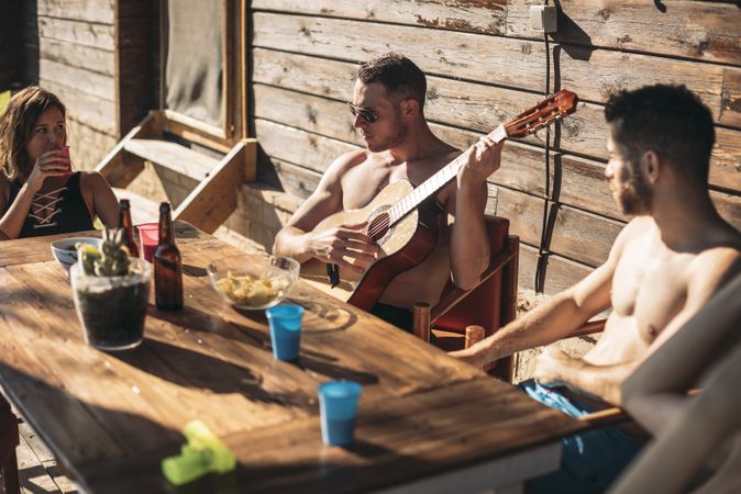 Guy playing guitar for his friends