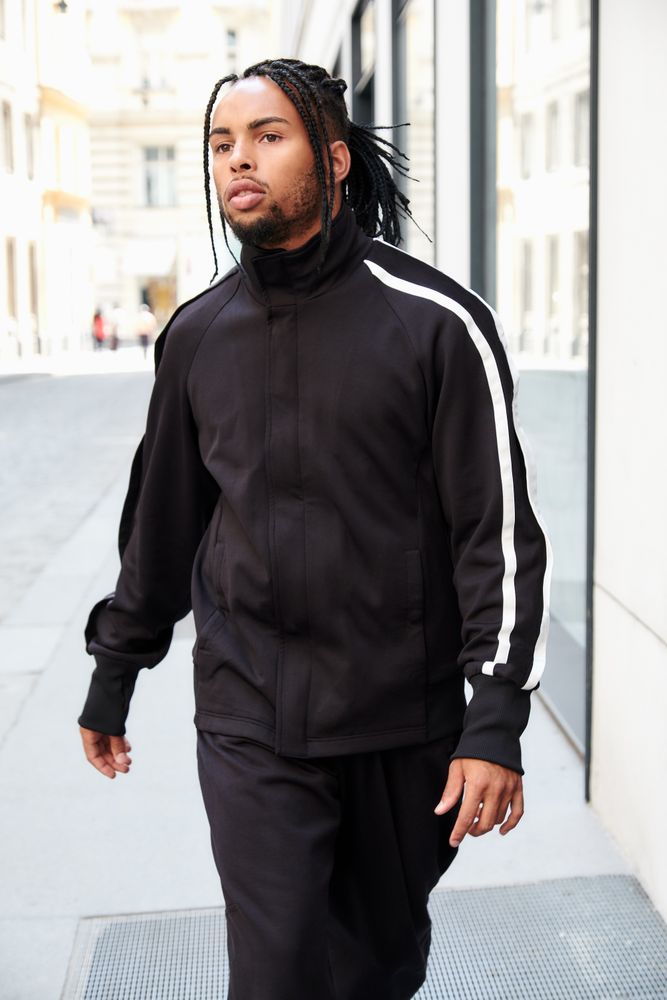 Black braided male walking down street